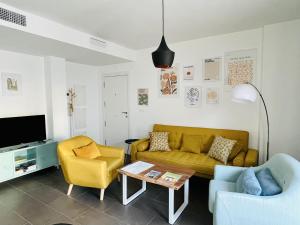 ein Wohnzimmer mit einer Couch und zwei Sesseln in der Unterkunft Coello 31 in Jaén