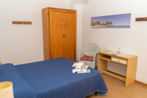 a bedroom with a blue bed and a desk at Casa Secci in Santa Maria Navarrese
