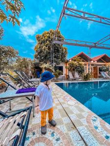 a little boy standing in front of a swimming pool at Tam Coc Sunrise Homestay in Ninh Binh