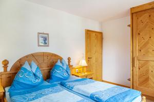 a bedroom with a bed with blue pillows at Landhaus Sonja 1 in Leutasch