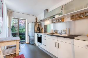 a kitchen with white cabinets and a large window at 2rad-freunde in Brannenburg