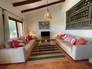 a living room with two couches and a tv at Nostra Caseta villa with pool & marina view near beaches in Cielo de Bonaire 