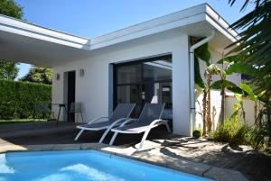 un patio con 2 sillas y una piscina en Chambre SOKA, en Urrugne