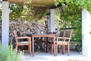 a wooden table and chairs under a pergola at Three sisters in Rudine