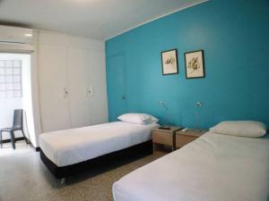 Habitación de hotel con 2 camas y pared azul en Casa Mandala en Los Cristales, en Cali