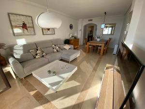 uma sala de estar com um sofá e uma mesa em Huge Rooftop Solarium With See View - 3 rooms em Benahavís