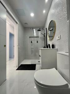 y baño blanco con aseo y ducha. en Apartamento Casa Blanca, en Las Palmas de Gran Canaria