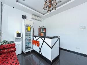 a living room with a refrigerator and a red couch at Super OYO 90364 Hotel Gemilang in Kuala Terengganu