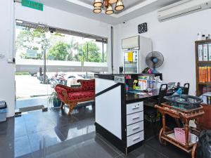 a kitchen with a desk and a couch in a room at Super OYO 90364 Hotel Gemilang in Kuala Terengganu