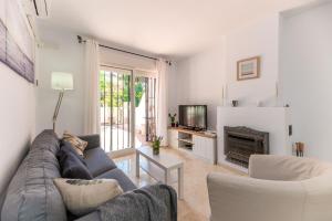 - un salon avec un canapé et une cheminée dans l'établissement VB Seguiriyas - 3BDR Relax Townhouse, à Benalmádena