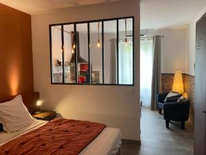 1 dormitorio con cama y espejo en la pared en Les lofts, en LʼIsle-sur-la-Sorgue