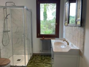 a bathroom with a sink and a glass shower at CARLIN Ferme Haute Prairie in Lourmarin