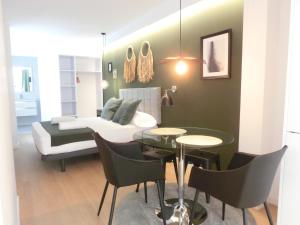 uma sala de estar com um sofá, uma mesa e cadeiras em Total Valencia Torres de Quart em Valência