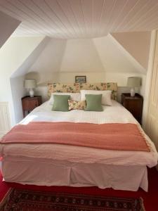a bedroom with a large bed with green pillows at Find Me Out Holiday Cottage in Dalmellington
