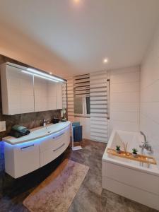 a bathroom with a tub and a sink and a bath tub at Haus Moor Merland in Moormerland +60 photos