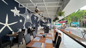 un restaurante con mesas de madera, sillas y estrellas en la pared en La Posada Jungle Hotel en Manuel Antonio