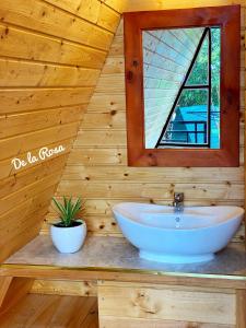 ein Badezimmer mit einem Waschbecken und einem Spiegel an einer Holzwand in der Unterkunft Homestay De la Rosa - Côn Đảo in Con Dao