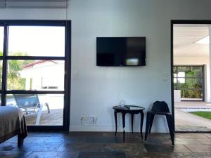 1 dormitorio con mesa y TV en la pared en Chambre SOKA, en Urrugne