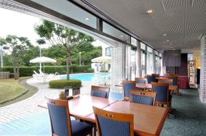 京丹後的住宿－雷索匹亞久美浜酒店，一间带桌椅的餐厅和一个游泳池