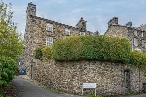 a stone building with a bush on the side of it at Dolgellau Townhouse 2 Minutes to Town & Mountains in Dolgellau