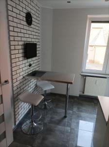 a table and two stools in a room with a window at Przy Katedrze in Koszalin