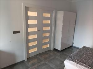 a bedroom with a bed and a closet and a door at Przy Katedrze in Koszalin