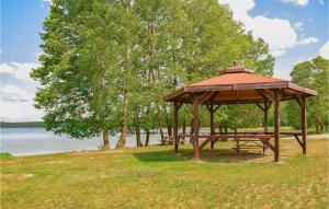 a wooden gazebo in a park next to a lake at Beautiful Apartment In Dominikowo With Wifi in Dominikowo