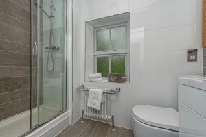 a white bathroom with a shower and a toilet at Dolgellau Townhouse 2 Minutes to Town & Mountains in Dolgellau +28 photos