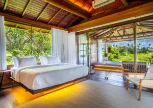 a bedroom with a large bed and large windows at Pousada Eco Luar in Igarassu