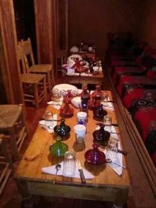 a long wooden table with tea sets on it at Auberge lac d'ifni in Aoulouz