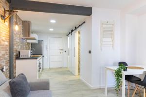 cocina y sala de estar con pared de ladrillo en Acogedor Loft Bazán - Alicante Centro en Alicante