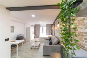 a living room with a couch and a brick wall at Acogedor Loft Bazán - Alicante Centro in Alicante