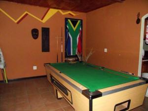 a room with a pool table in a room with a flag at Sabie Gypsy's Backpackers in Sabie