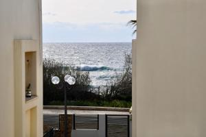 einen Blick auf das Meer von einer Tür aus in der Unterkunft Hoffman Executive Suites - Beachfront Nahariya in Naharija