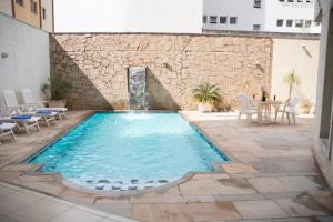 a swimming pool with a waterfall in a building at Mariano Palace Hotel in Campinas