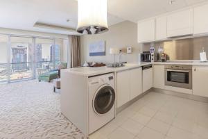 a kitchen with a washer and dryer in a room at Emaar Fashion Avenue - Formerly Address Dubai Mall Four Apple in Dubai