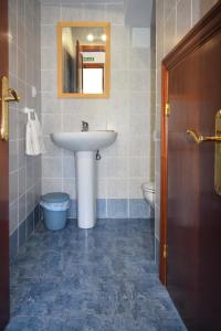 uma casa de banho com um lavatório e um WC em Apartamentos Rurales la Taberna em Matienzo