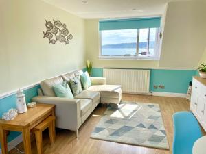 uma sala de estar com um sofá e uma mesa em Lighthouse View, one min from harbour & beach em Scarborough