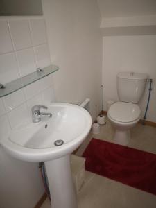 a bathroom with a white sink and a toilet at Appartement Chaleureux in Albert