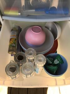 un réfrigérateur rempli de vaisselle et d'autres articles dans l'établissement Ffos Wilkin Glamping & Alpacas, à Kidwelly