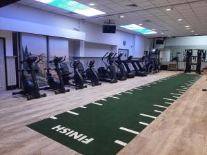 a gym with treadmills and a row of tread machines at Vitaliteitscentrum Brabant in Vierlingsbeek