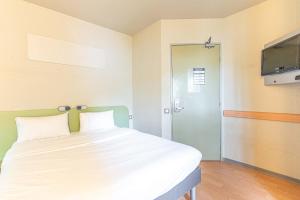 1 dormitorio con 1 cama y TV de pantalla plana en Fasthotel Cleon Rouen Sud en Cléon