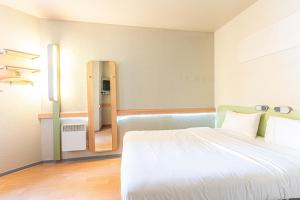 1 dormitorio con 1 cama grande y espejo en Fasthotel Cleon Rouen Sud en Cléon