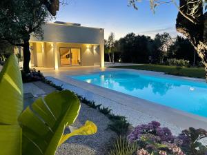 a swimming pool in front of a house at Resort Natura & Relax in Sestu