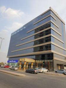 un grand bâtiment avec des voitures garées dans un parking dans l'établissement Al Rayyan Tower, à Djeddah