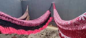two red hammocks are hanging in a room at Pousada Casa da Vovó - Sua casa pertinho da Praia in Aracaju
