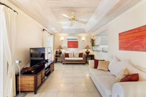 a living room with a couch and a tv at White Sands Beach Villas - Villas N- Lovely 1 Bed Condo in Christ Church