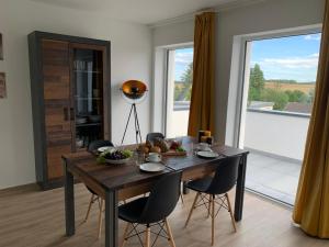 a dining room with a table and chairs and a window at eifel24, neues und modernes Appartement mit Dachterrasse in Schwirzheim