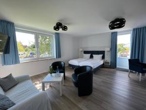 uma sala de estar com 2 camas e um sofá e cadeiras em Gästehaus Blauth em Cuxhaven