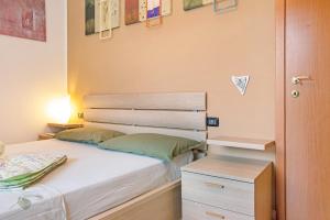 a small bedroom with a bed and a night stand at A due passi dal lago in Laveno-Mombello